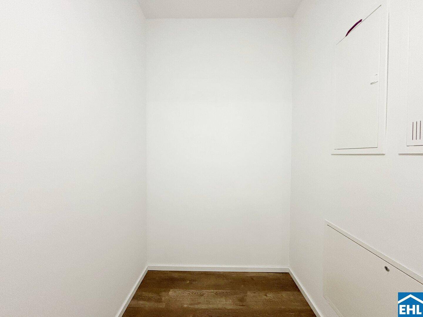 Praktischer Abstellraum mit Laminatboden und weißen Wänden für zusätzlichen Stauraum im Haushalt.