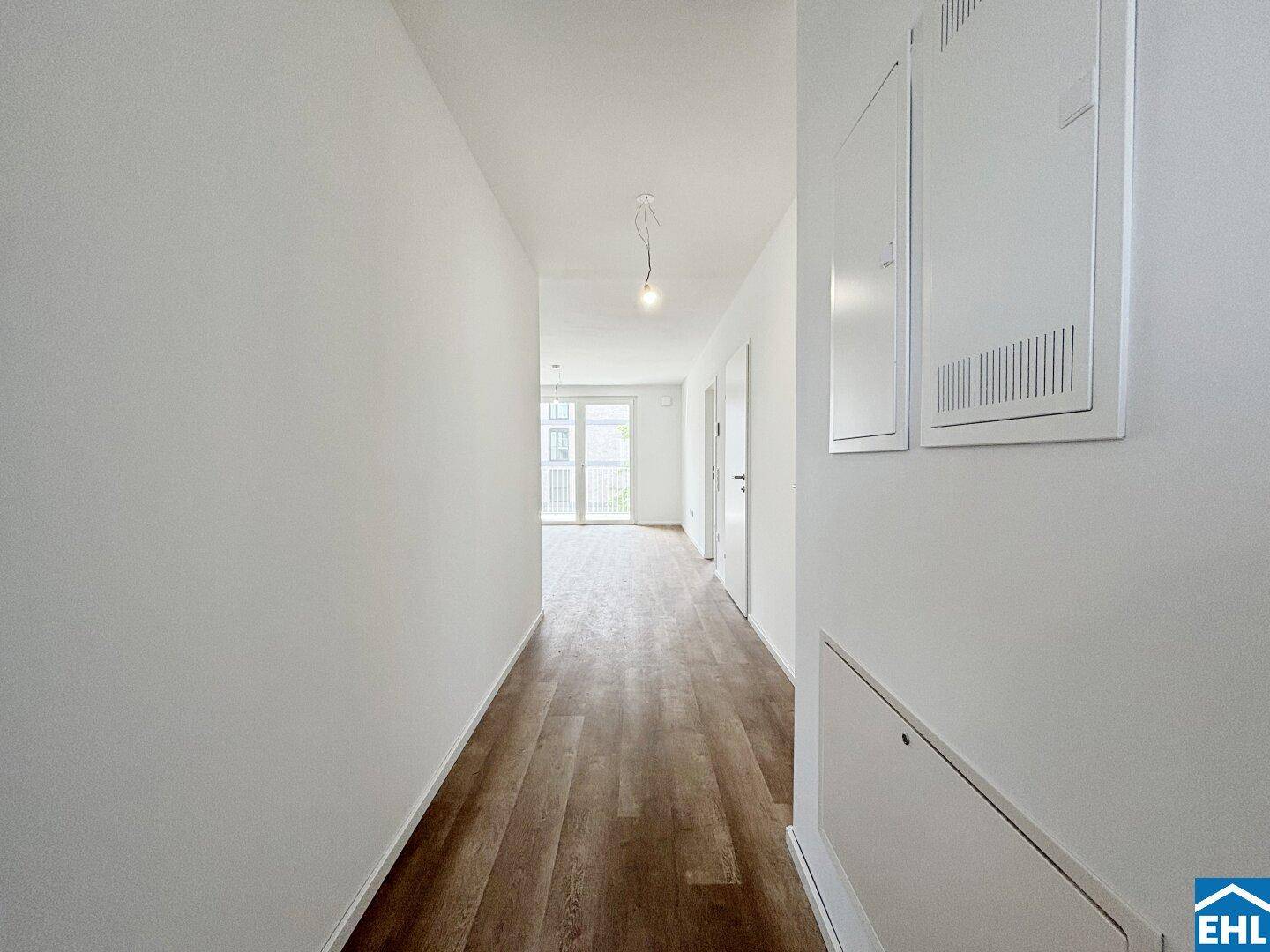 Heller Flur mit Laminatboden, der zu den verschiedenen Wohnbereichen führt.