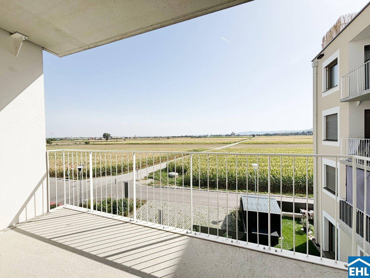 Geräumiger Balkon mit weitem Blick über Felder und die ländliche Umgebung.