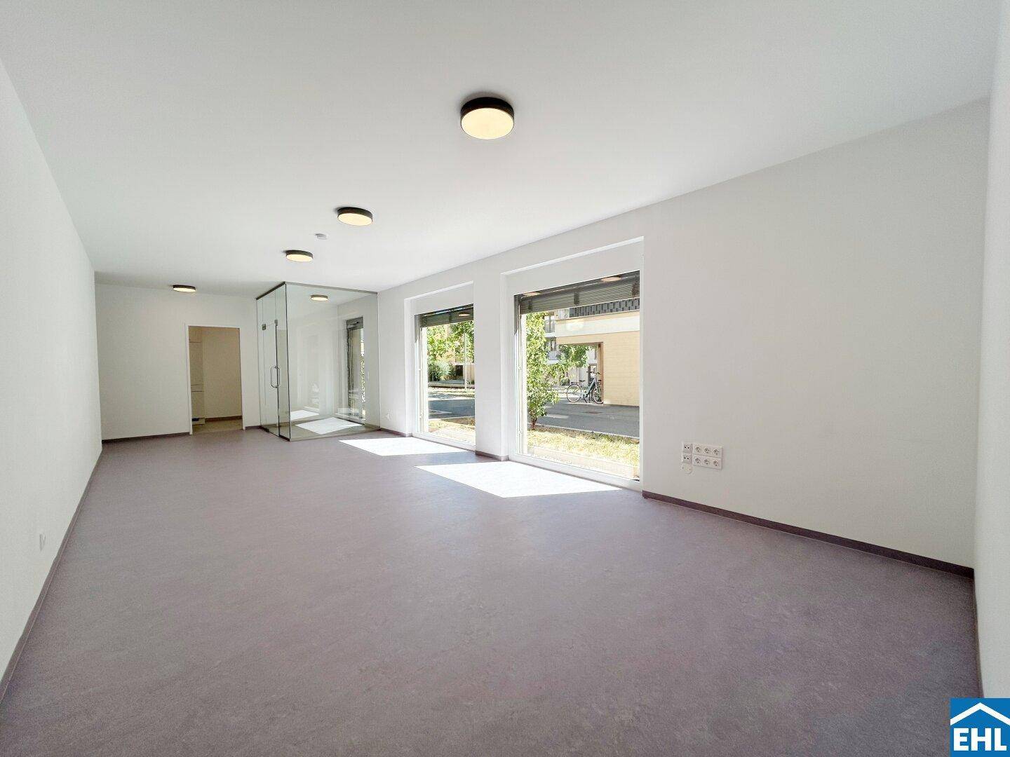 Geräumiges, helles Zimmer mit großen Fenstern und Blick nach draußen, ideal für flexible Nutzung.