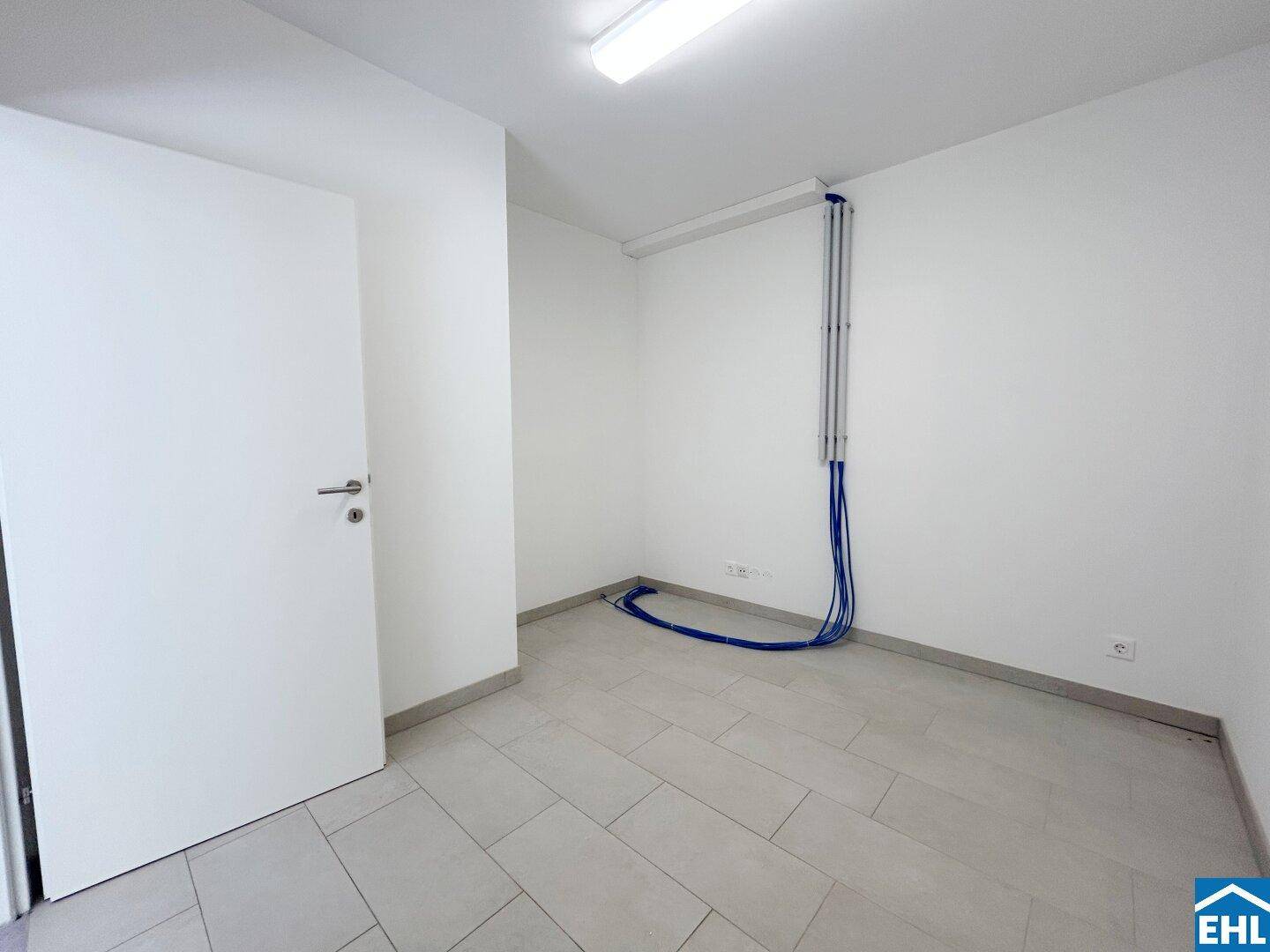Funktionaler Raum mit Fliesenboden und Wandinstallationen, geeignet für Haustechnik oder Lagerung.