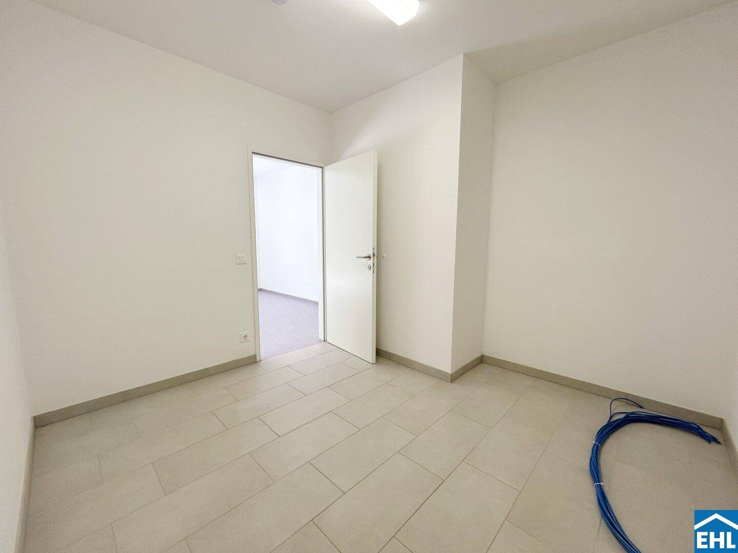 Praktischer Raum mit Fliesenboden und sichtbaren Installationen, ideal als Abstell- oder Technikraum.