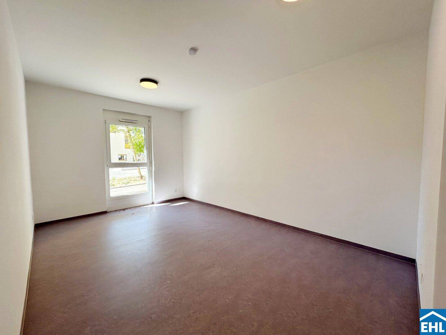 Ruhiges, helles Zimmer mit einem Fenster und Blick ins Freie, ideal als Schlaf- oder Arbeitszimmer.