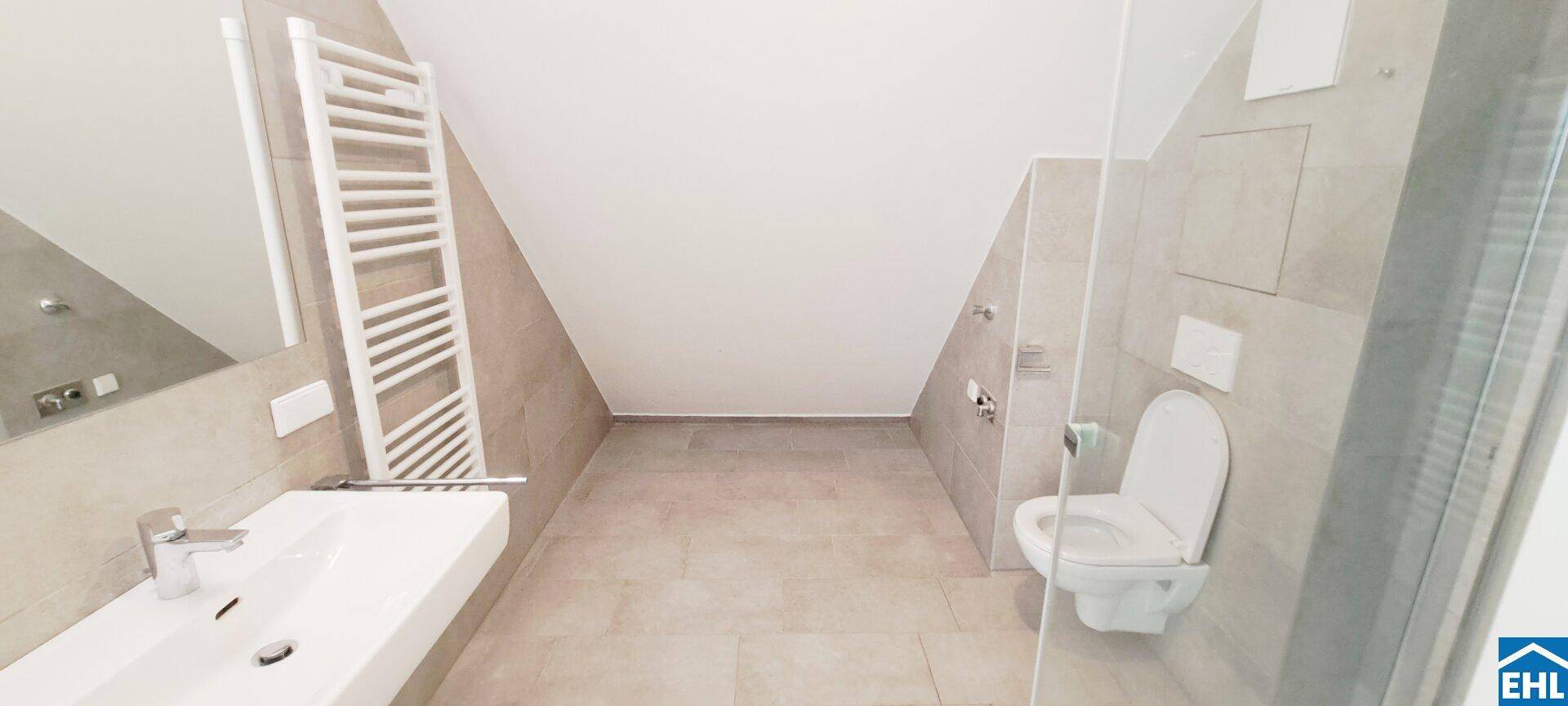 Modernes Badezimmer mit begehbarer Dusche, WC, Waschbecken und Handtuchheizkörper.