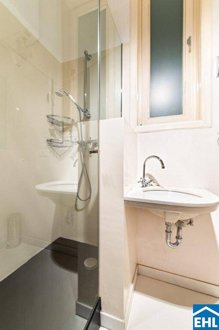 Modernes Badezimmer mit Dusche, Waschbecken und Fenster für Tageslicht.