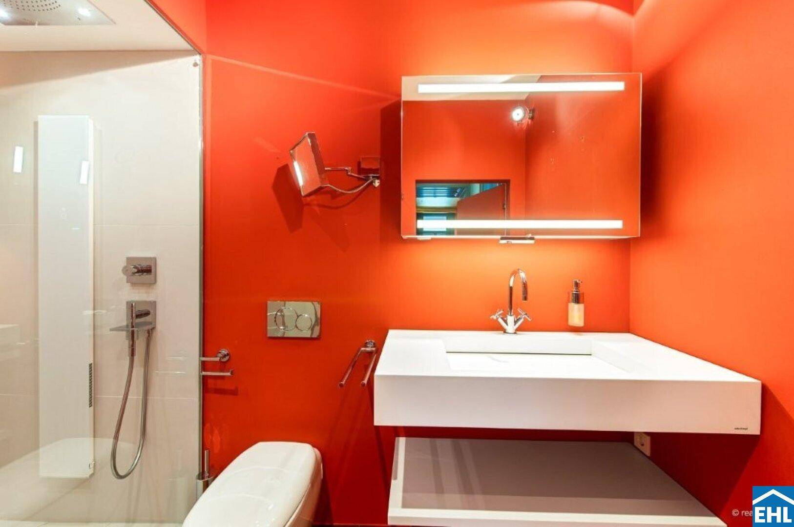 Modernes Badezimmer mit leuchtend roten Wänden, Duschkabine und minimalistischem Waschbecken.