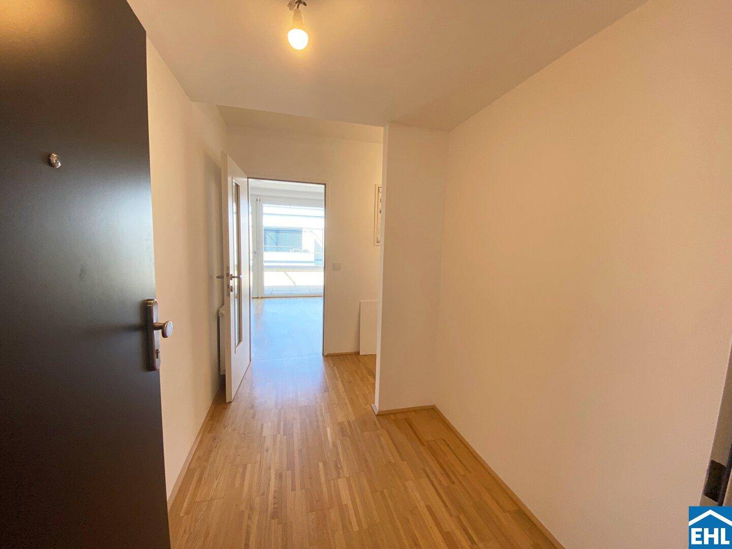Heller Flur mit Holzfußboden, der zu den verschiedenen Wohnbereichen führt.