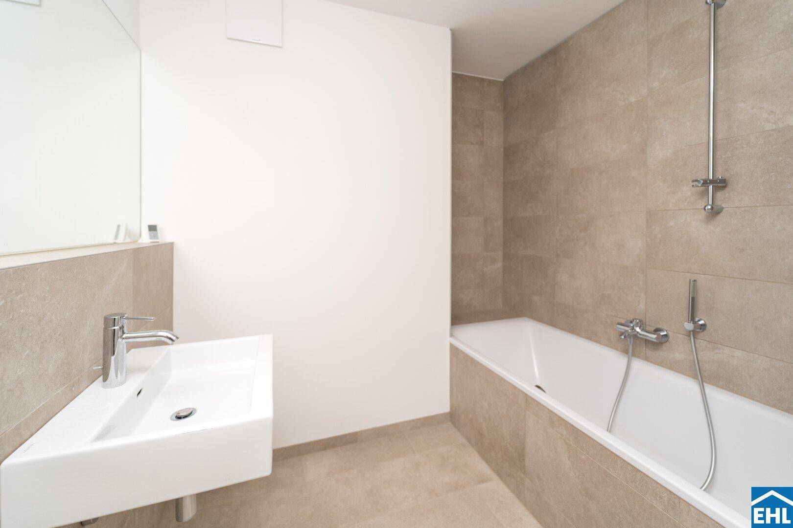 Modernes Badezimmer mit Badewanne, Einzelwaschbecken und beigefarbenen Fliesen.