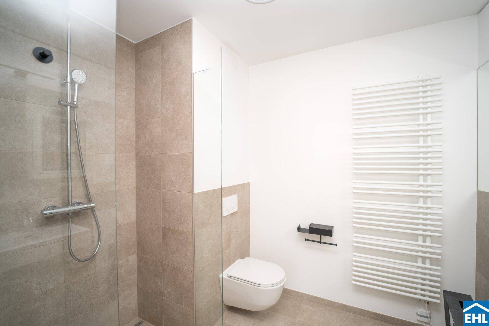 Modernes Badezimmer mit begehbarer Dusche, Wand-WC und Handtuchheizkörper.
