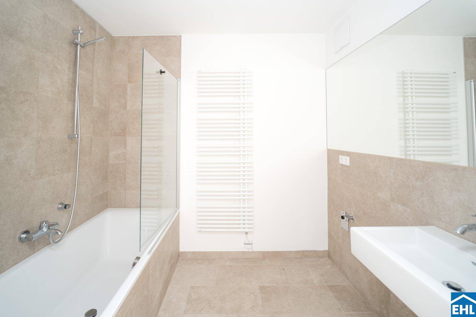 Modernes Badezimmer mit Badewanne, Einzelwaschbecken und großem Spiegel.
