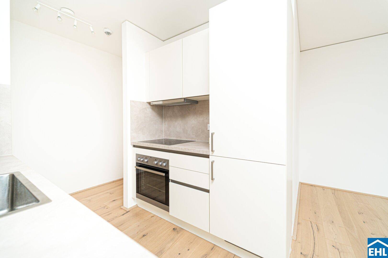 Kompakte Küchenzeile mit integriertem Backofen und Induktionskochfeld, ideal für kleine Wohnungen.
