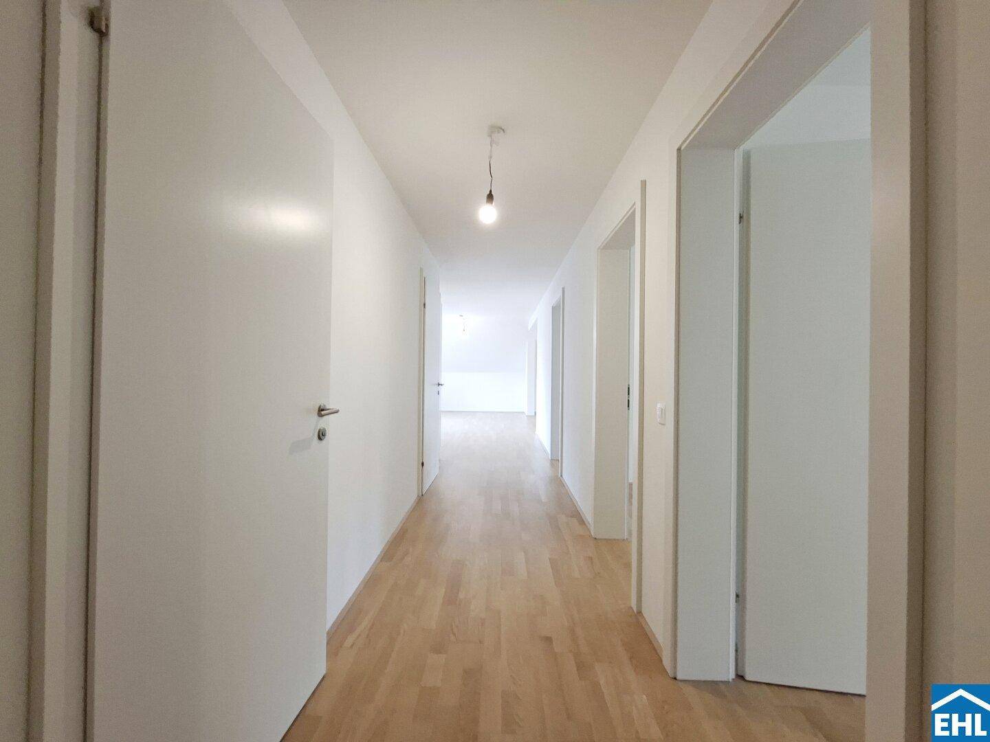 Heller Flur mit Holzfußboden und mehreren Türen zu den angrenzenden Räumen.