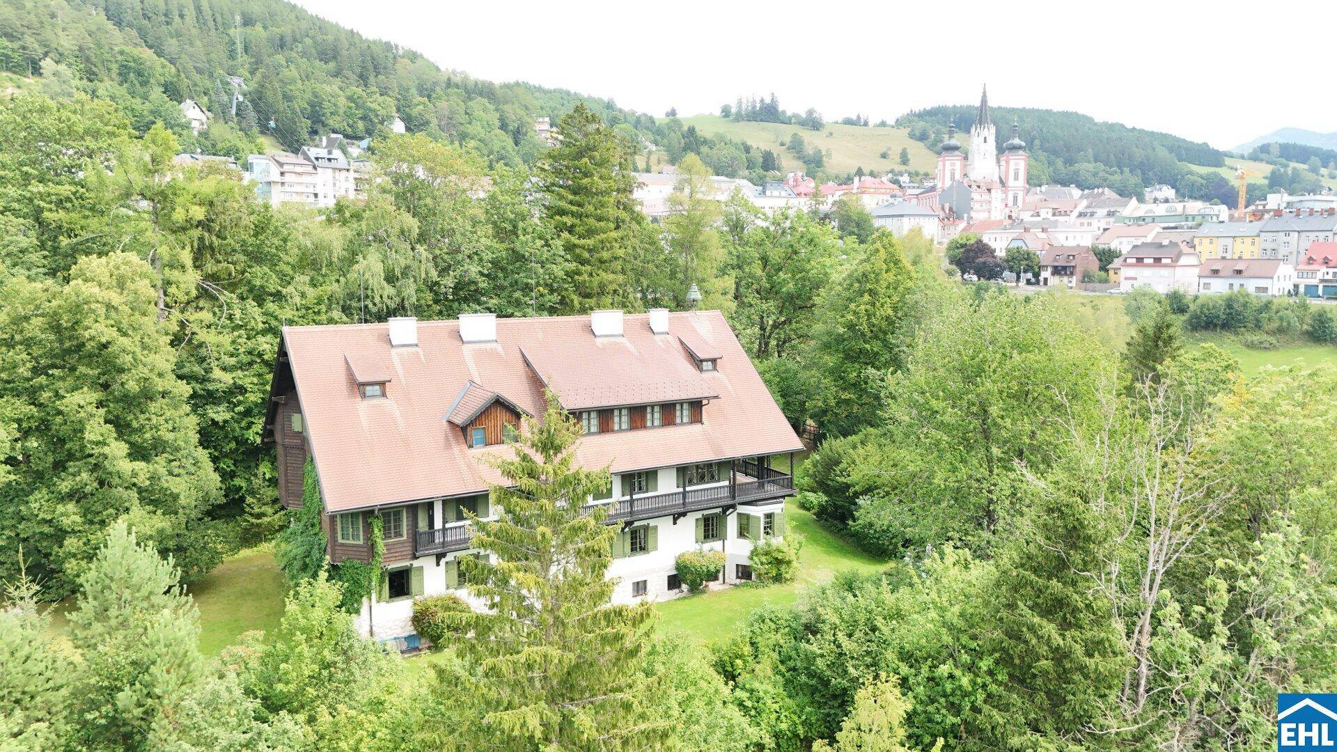 Historisches Anwesen mit Blick auf die umliegende Stadt, Berge und weite grüne Landschaft.