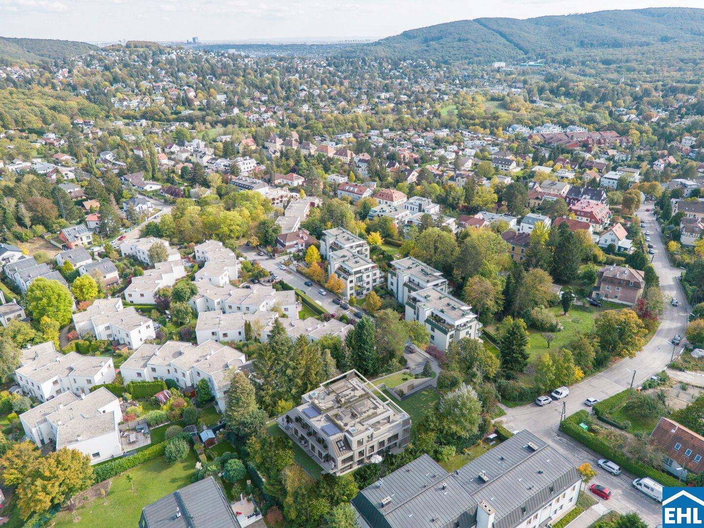 Luftaufnahme einer Wohngegend mit dem modernen Apartmentgebäude eingebettet in grüne Landschaft.