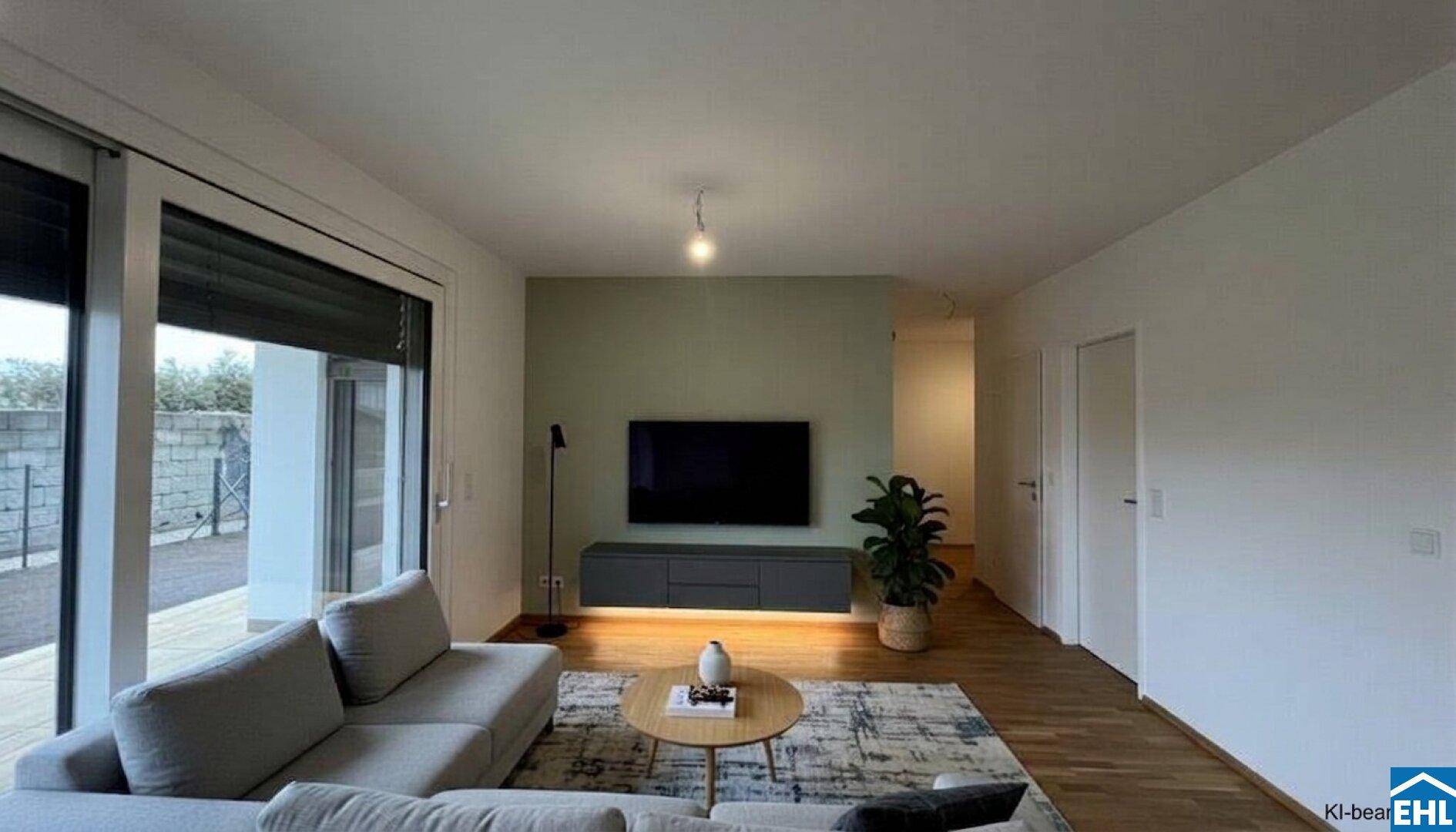 Modernes Wohnzimmer mit Fernseher, Sofa und Zugang zu einer Terrasse mit Außenbereich.