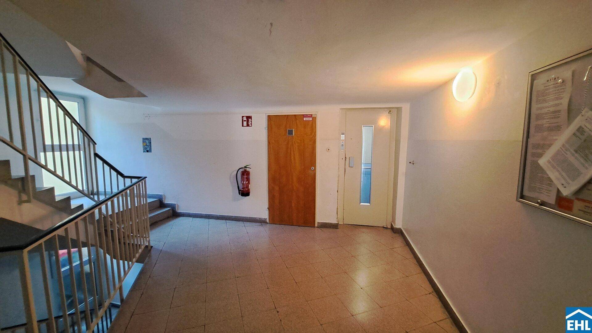 Treppenhaus und Flur eines Mehrfamilienhauses mit Zugang zu den Wohneinheiten.