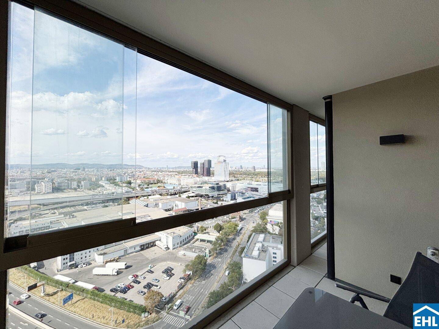 Verglaste Loggia mit weitem Blick über die Stadt und die umliegende Infrastruktur.
