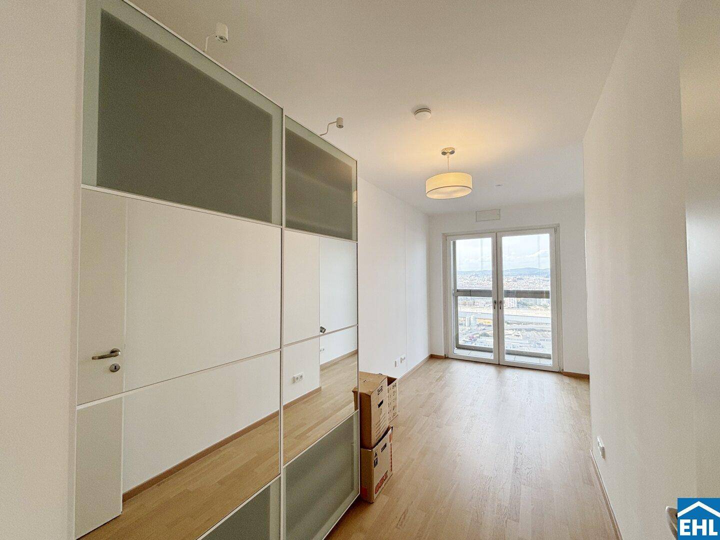 Helles Zimmer mit Spiegelschränken und großem Fenster, ideal als Schlaf- oder Arbeitszimmer.