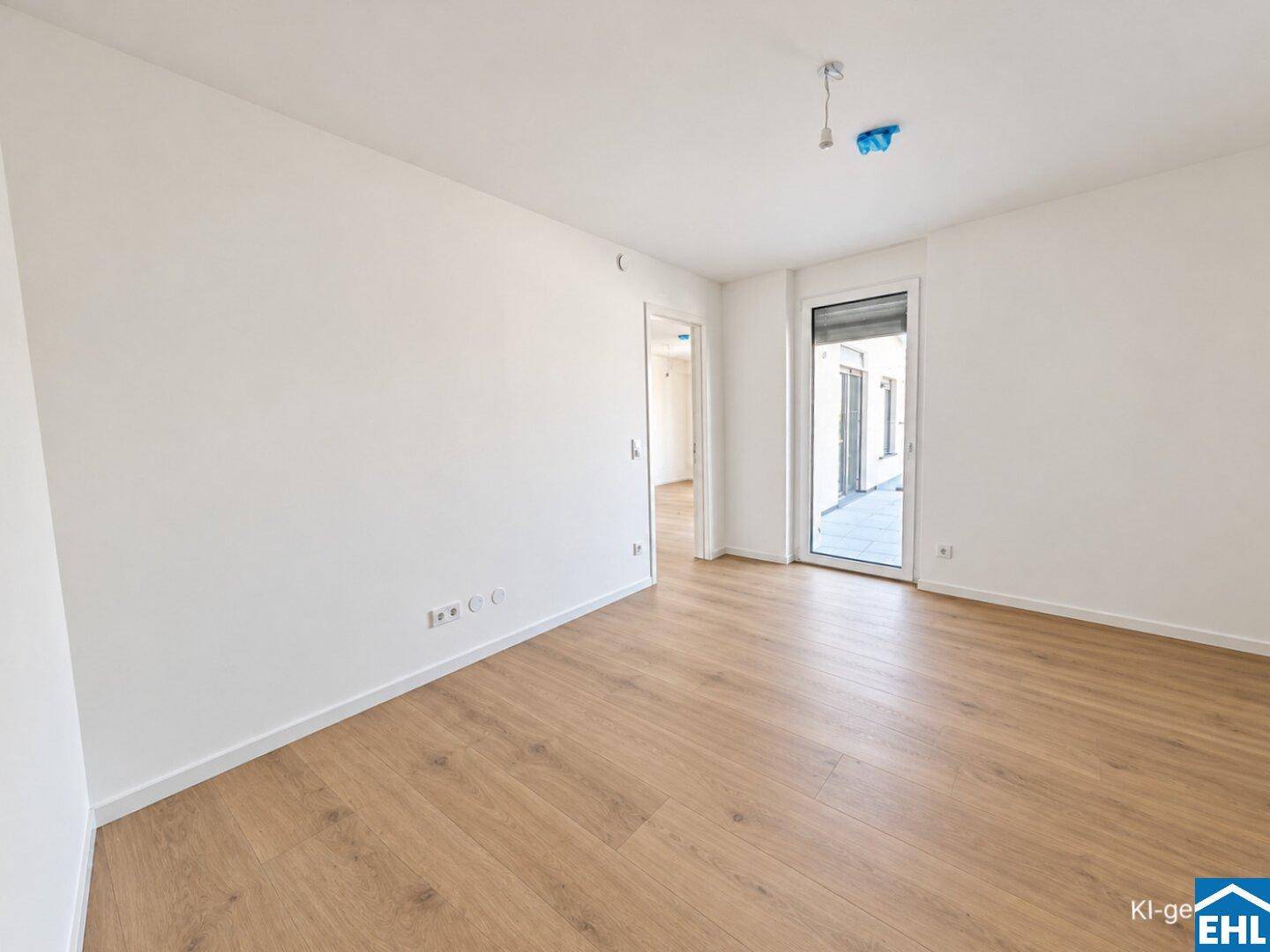 Leeres Schlafzimmer mit hellem Laminatboden und Zugang zu einem Außenbereich.