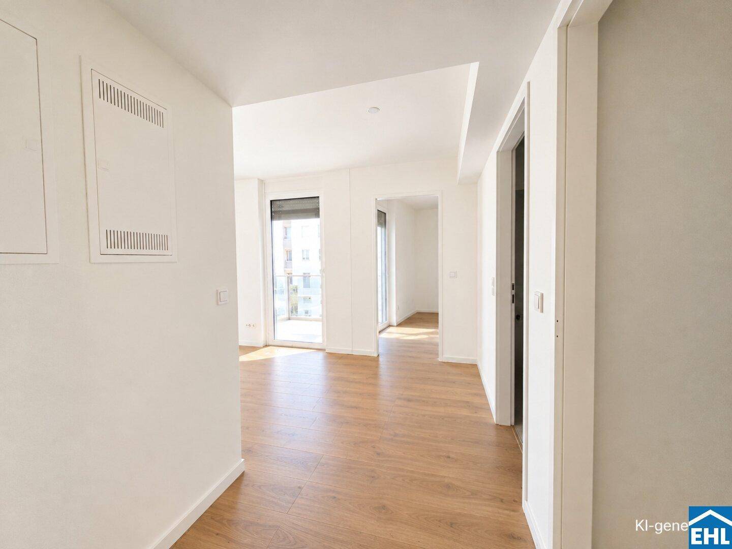 Heller Flur mit Laminatboden, der zu weiteren Räumen mit großen Fenstern führt.