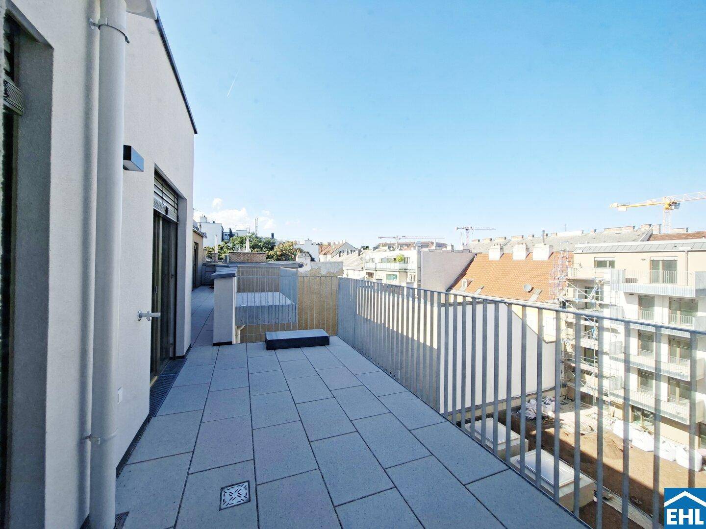 Geräumige Terrasse mit Fliesenboden und Blick über die Dächer der Stadt.
