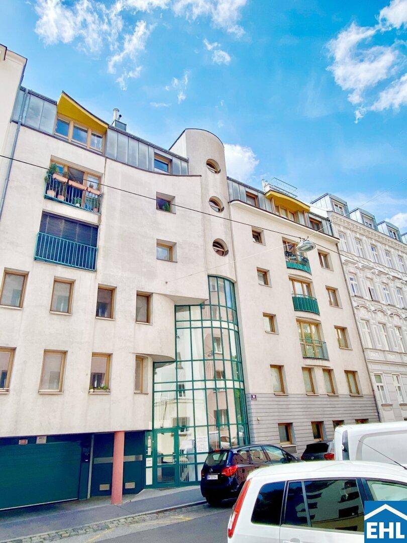 Moderne Gebäudefassade mit interessanter Architektur, großen Fenstern und Balkonen.