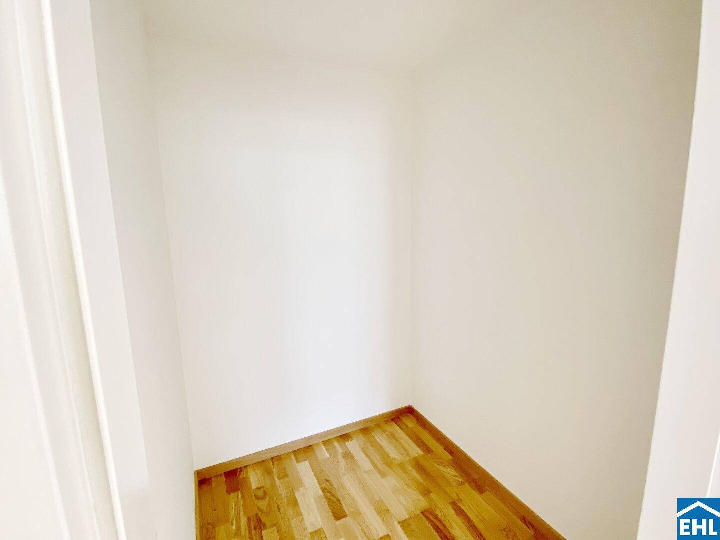 Kleiner Abstellraum mit Parkettboden und weißen Wänden, ideal für zusätzlichen Stauraum.