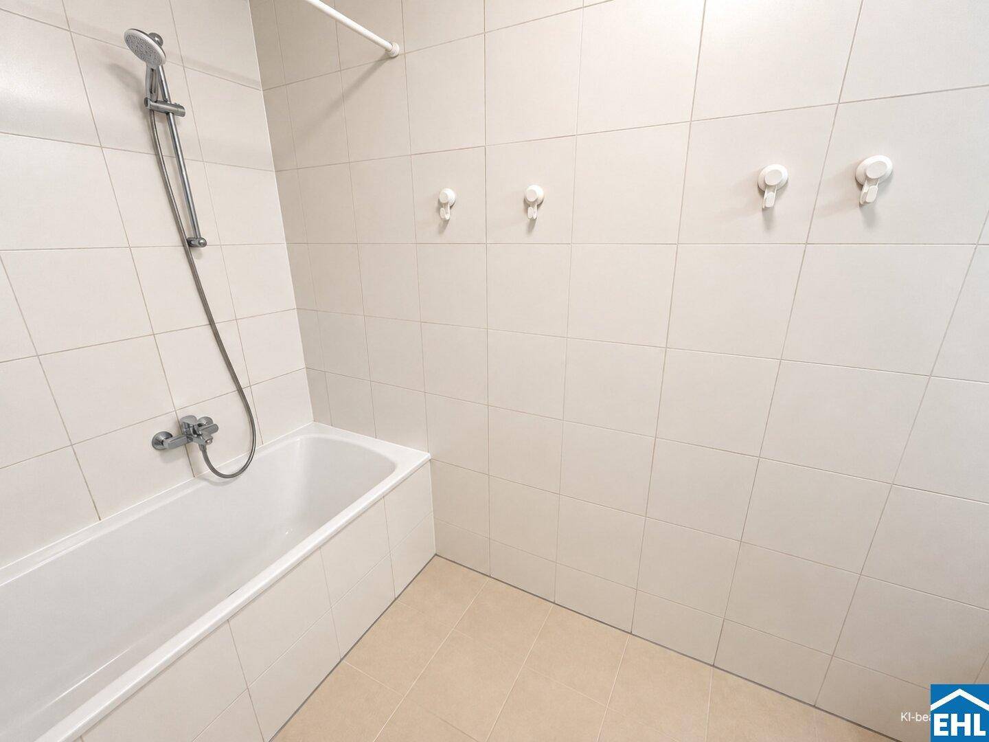Badezimmer mit weißen Fliesen, beigem Boden und einer Badewanne mit integrierter Dusche.