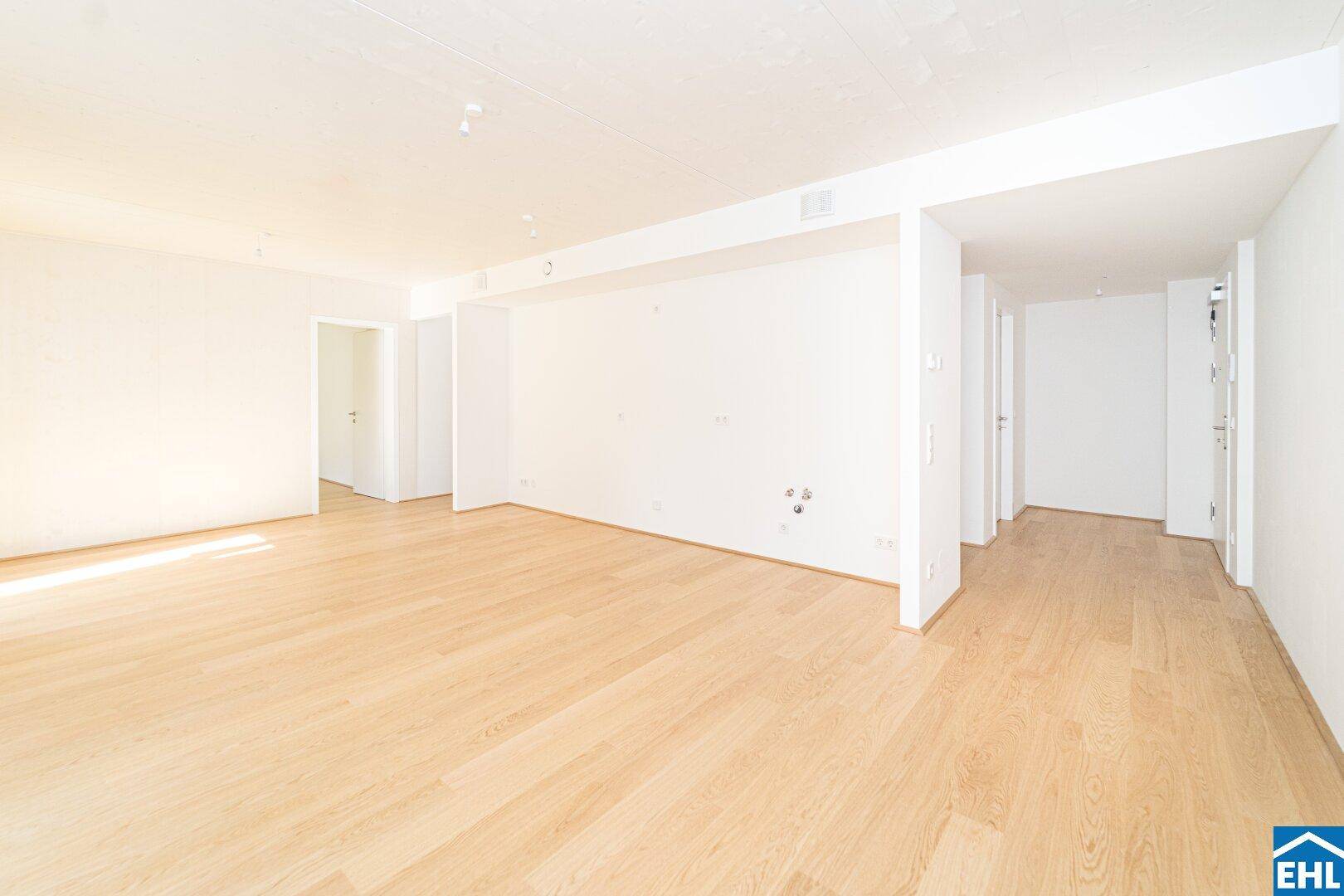 Geräumiger, heller Innenraum mit Holzboden und mehreren Türöffnungen.