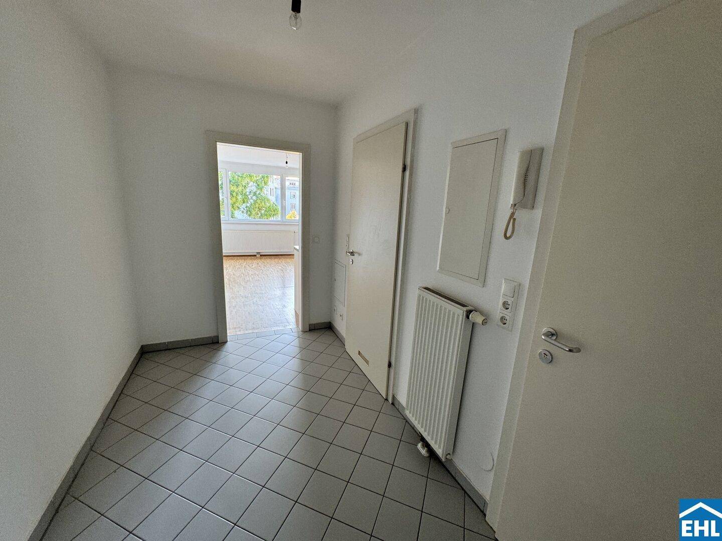 Heller Flur mit Fliesenboden und Zugang zu den weiteren Räumen der Wohnung.