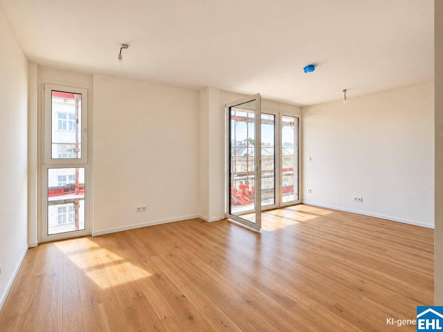 Lichtdurchflutetes, unmöbliertes Zimmer mit Holzboden und großen Fenstern.
