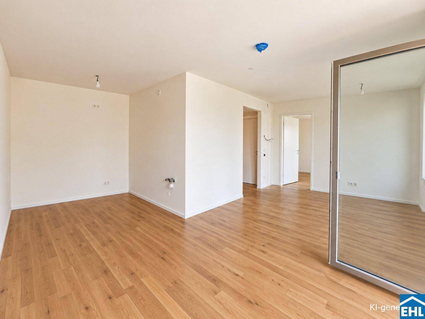 Heller Raum mit Holzboden und einem großen Spiegelschrank, der den Raum optisch erweitert.
