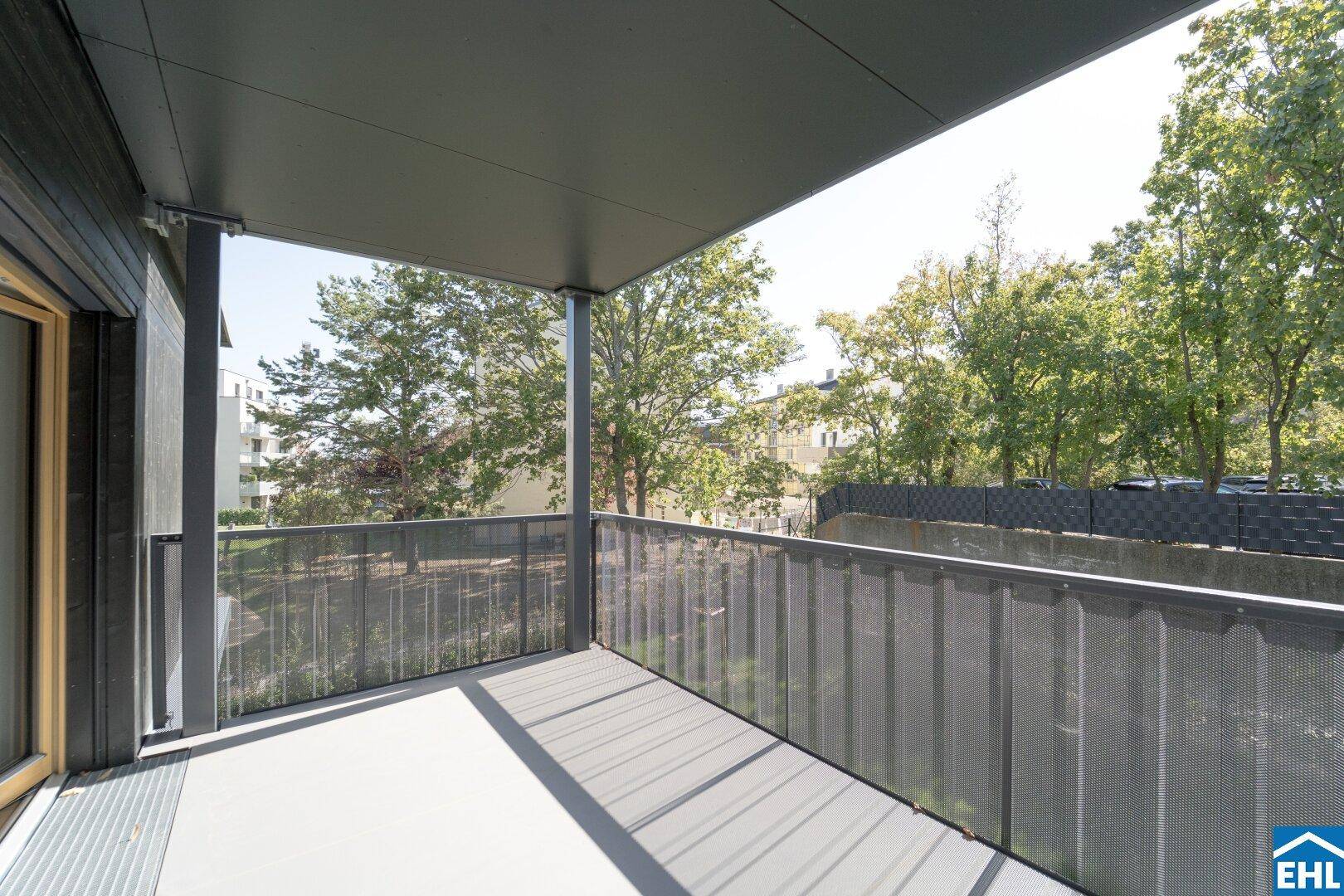 Überdachter Balkon mit modernem Metallgeländer und Blick ins Grüne, ideal zum Entspannen.