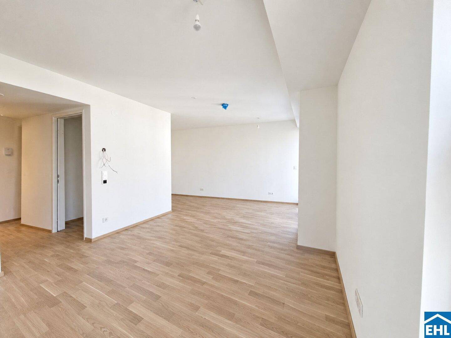 Weitläufiger, unmöblierter Raum mit Parkettboden und klaren Linien, ideal für individuelle Gestaltung.