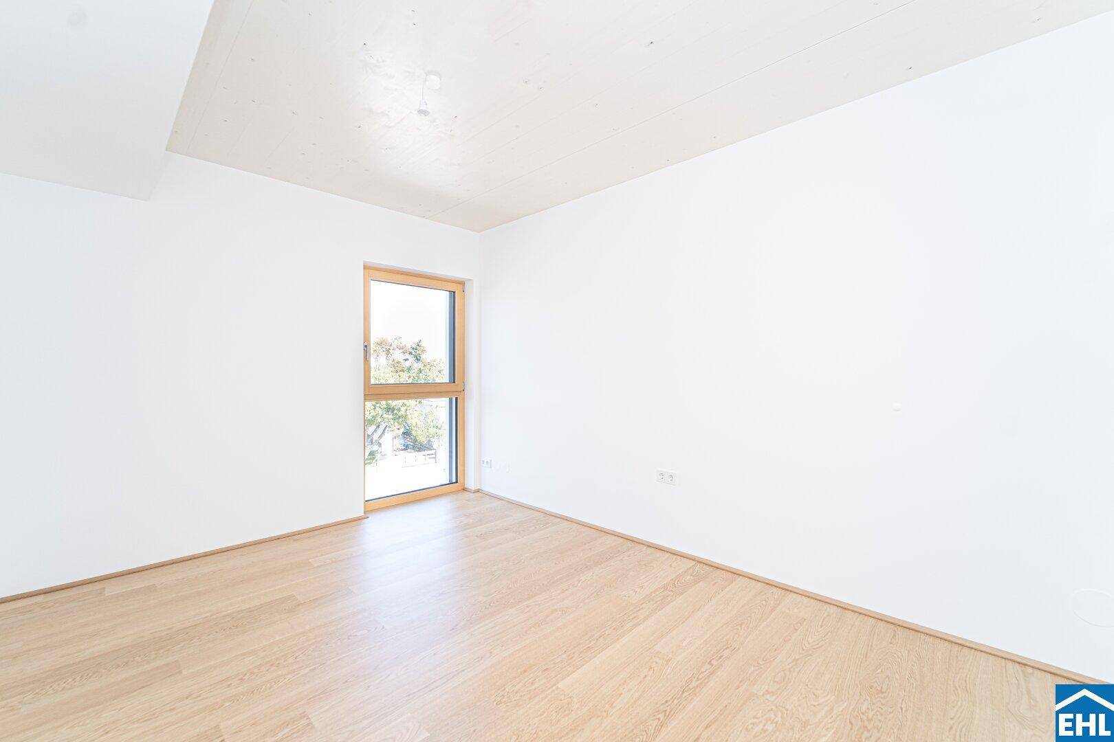 Weiteres helles Zimmer mit Parkettboden und Fenster, ideal als Schlaf- oder Arbeitszimmer.