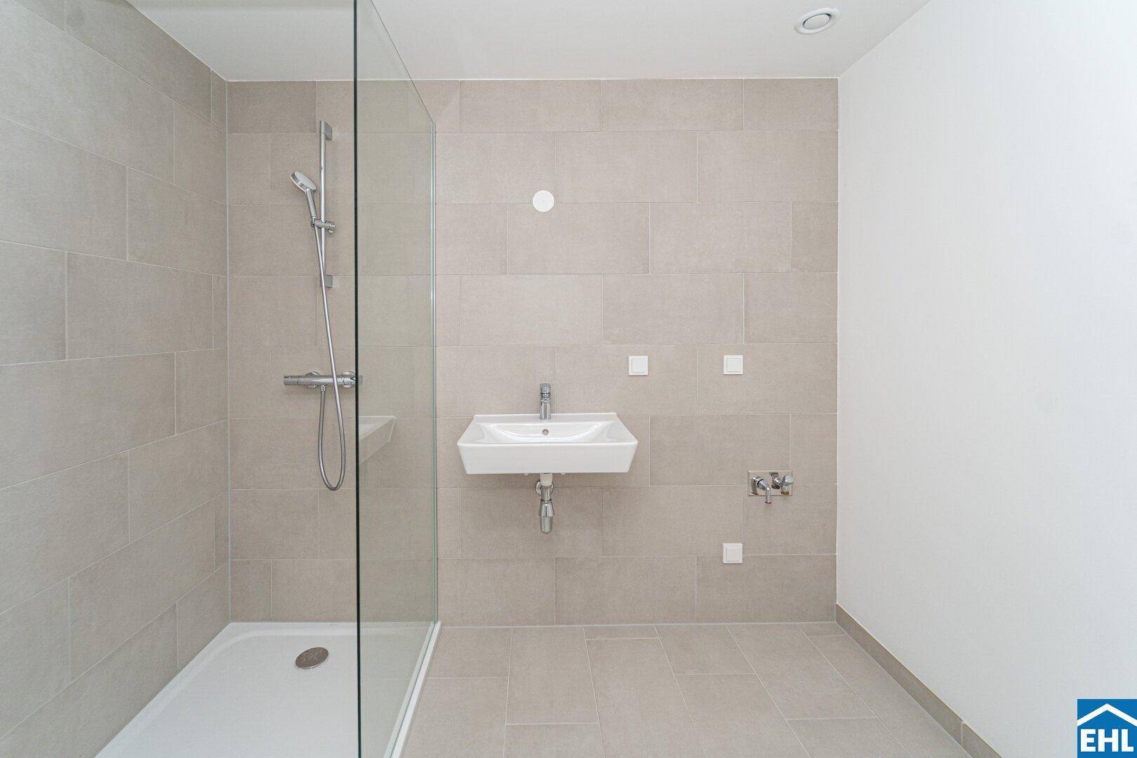 Modernes Badezimmer mit begehbarer Dusche, Einzelwaschbecken und hellgrauen Fliesen.