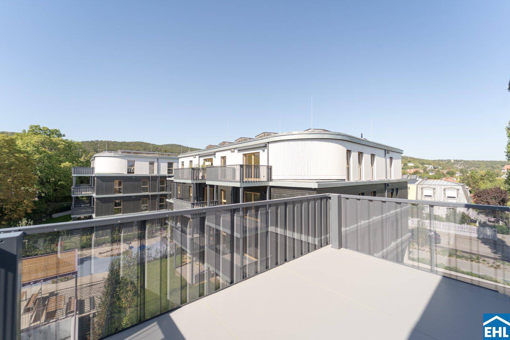 Blick vom Balkon auf die moderne Architektur des Neubaus mit weiteren Balkonen.