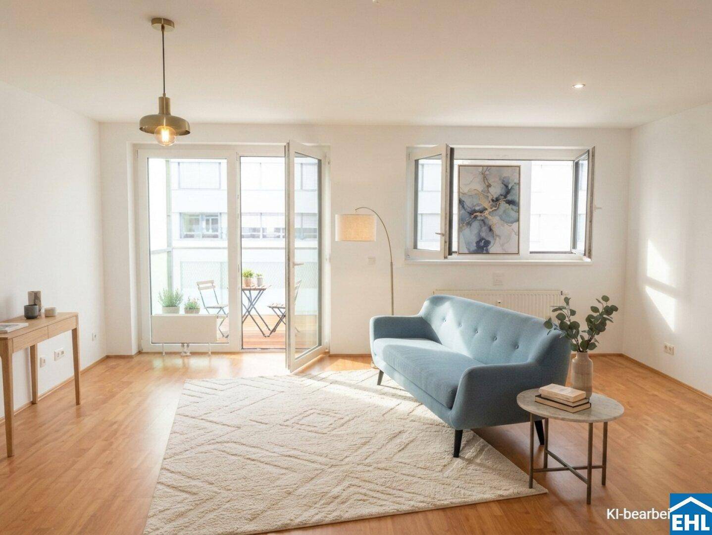 Helles Wohnzimmer mit Holzboden, modernem Sofa und Zugang zu einem Balkon.