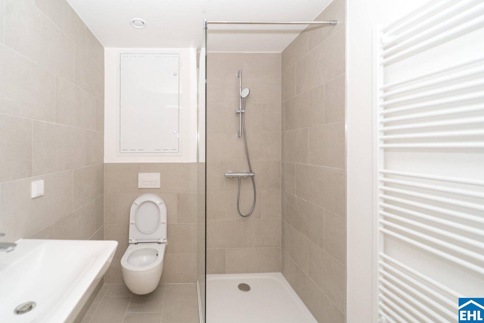 Modernes Badezimmer mit Dusche, wandhängendem WC und einem einzelnen Waschbecken.