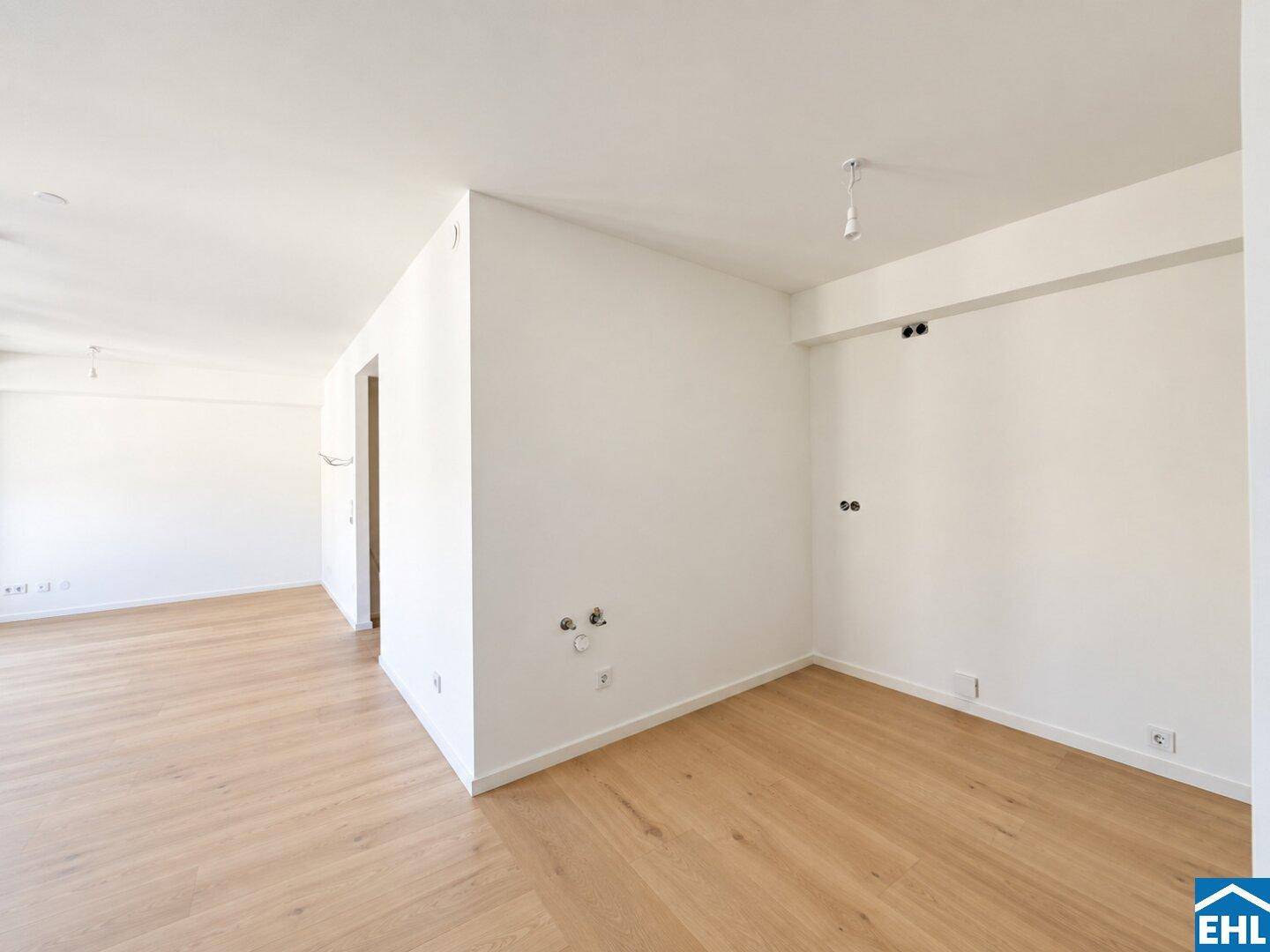 Leerer Raum mit hellen Wänden und Laminatboden, vorbereitet für die Installation von Geräten.