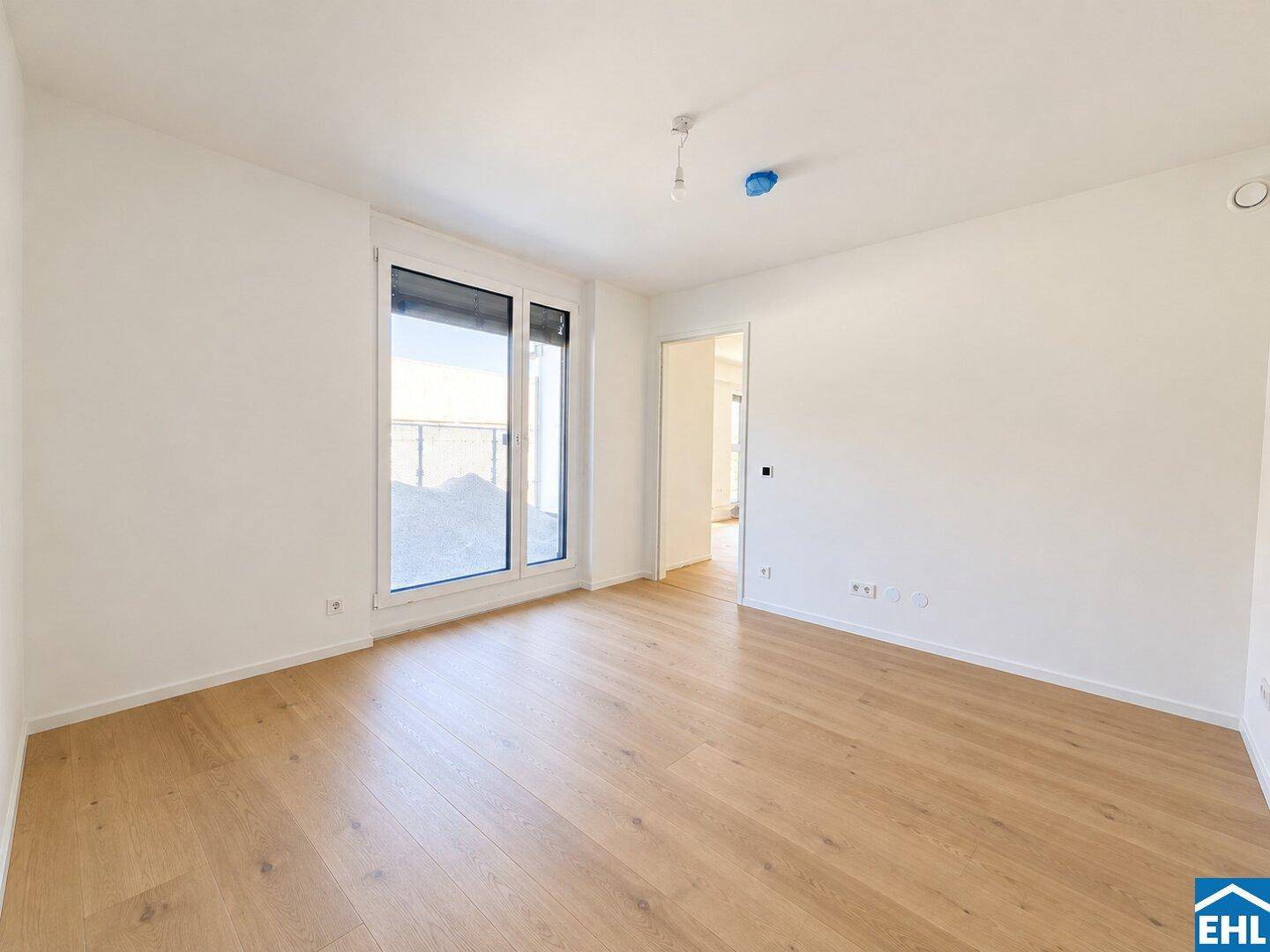 Geräumiges Schlafzimmer mit Laminatboden und Zugang zu einem Balkon, ideal für frische Luft.