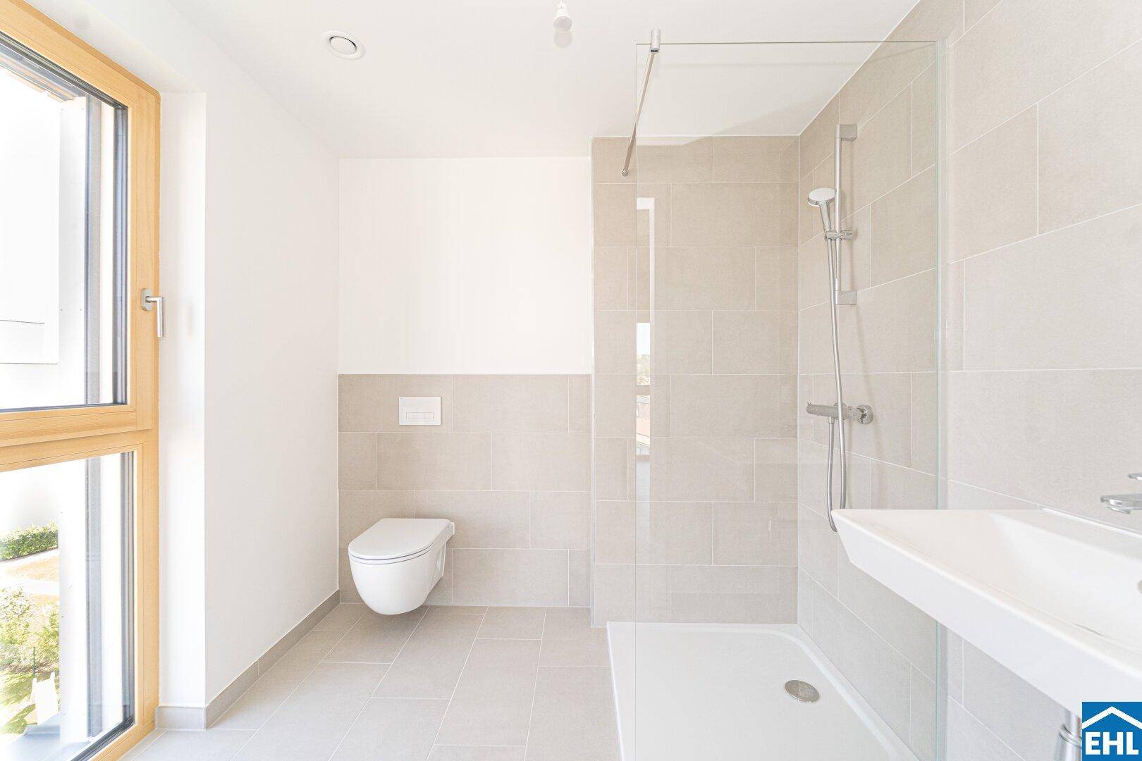Modernes Badezimmer mit begehbarer Dusche, wandhängendem WC und Fenster für Tageslicht.