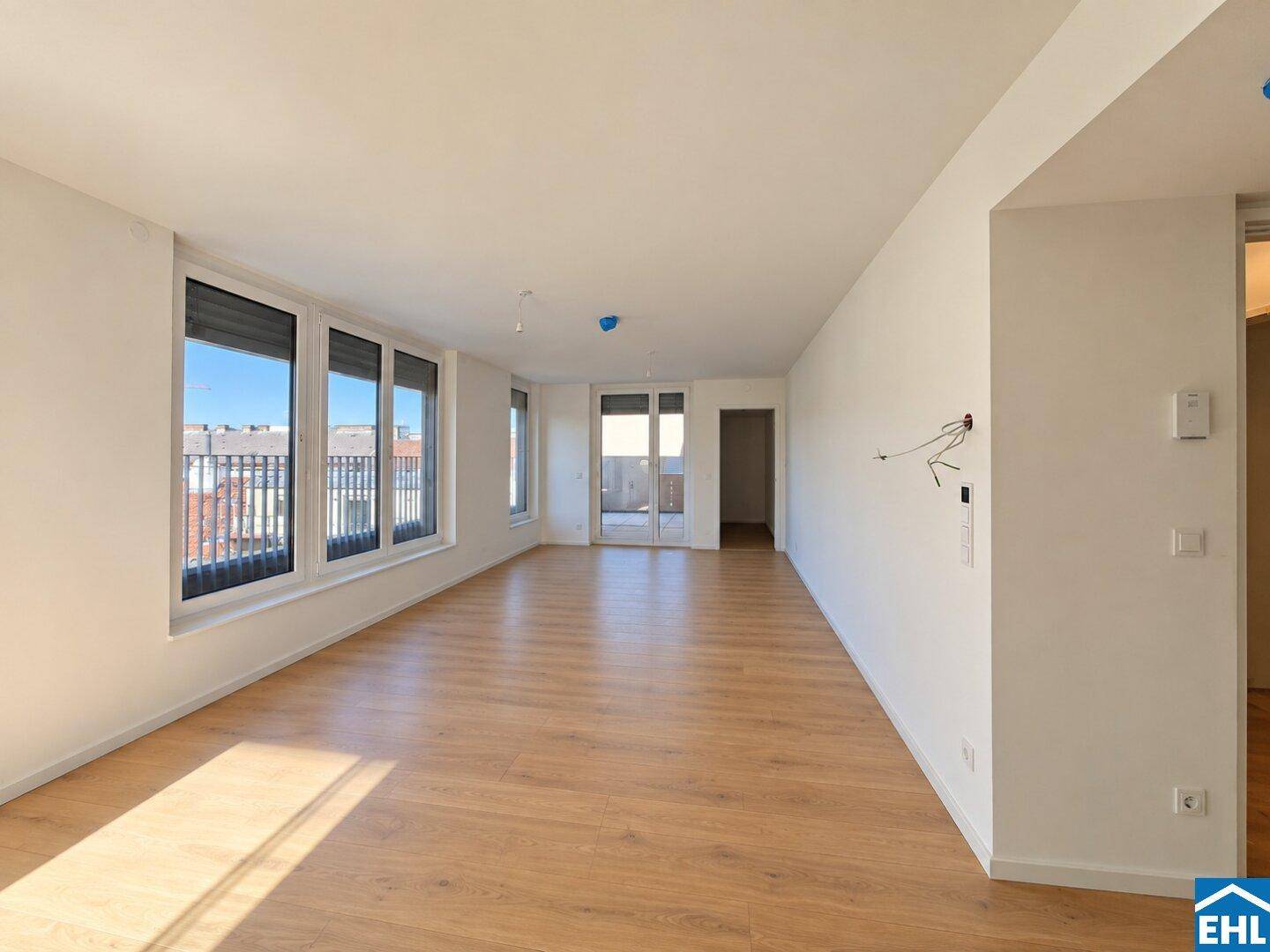 Großzügiger, heller Wohnraum mit Parkettboden und vielen Fenstern für viel Tageslicht.