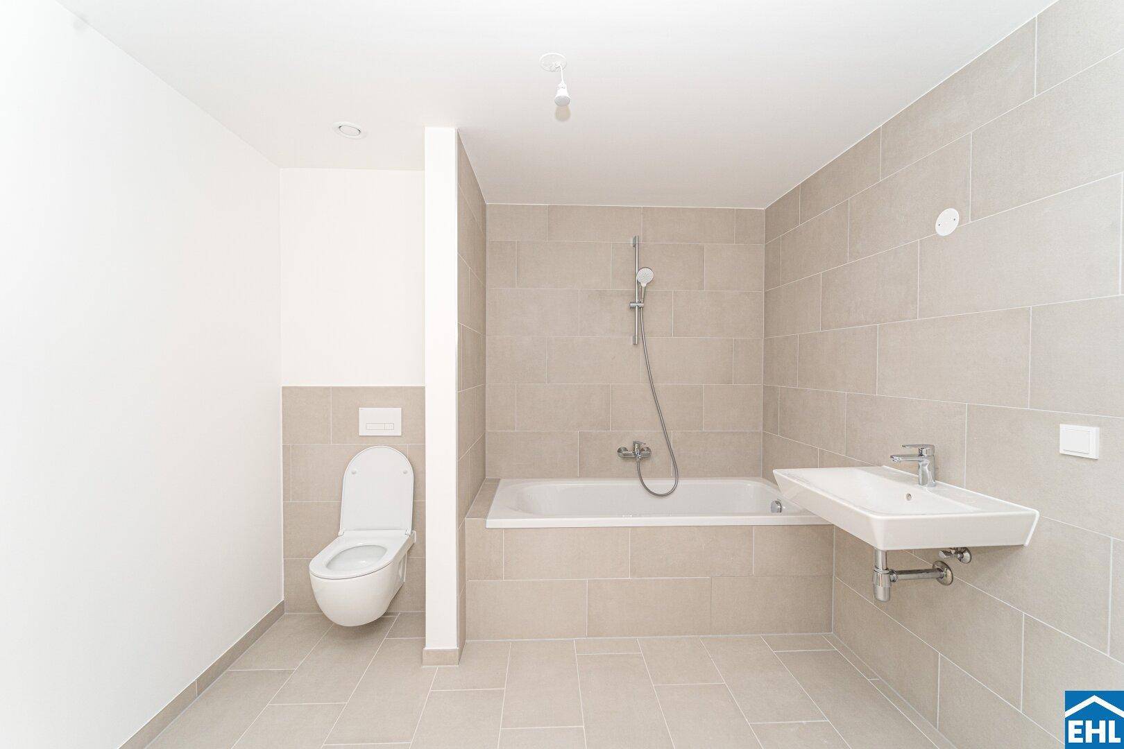 Helles Badezimmer mit Badewanne, wandhängendem WC und modernem Waschbecken.