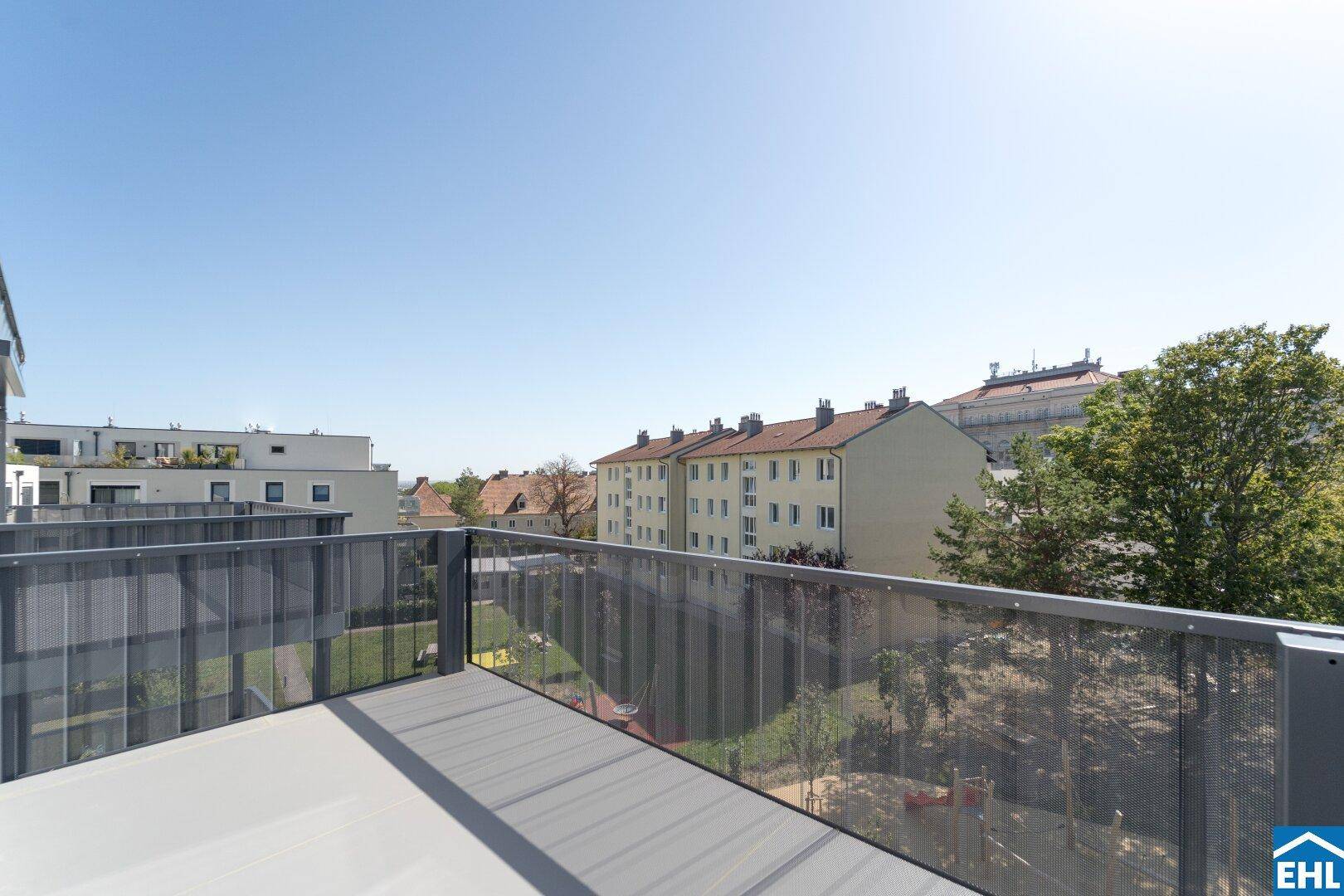 Geräumiger Balkon mit moderner Metallbrüstung und Blick auf die umliegenden Gebäude und Grünflächen.