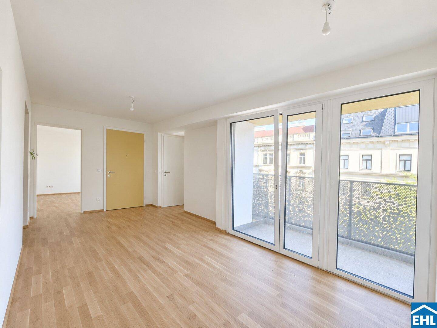 Lichtdurchfluteter Raum mit Parkettboden und Balkonzugang, ideal für einen großzügigen Wohnbereich.