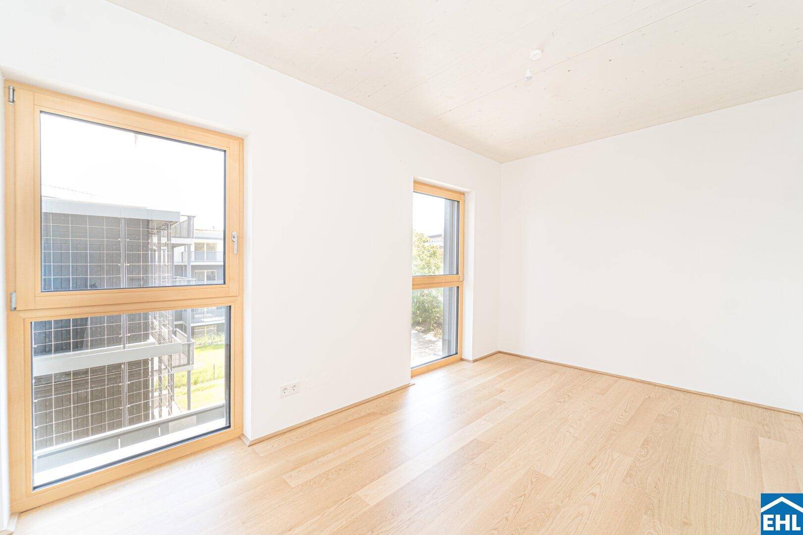 Helles Schlafzimmer mit großen Fenstern und hellem Holzfußboden, bietet viel Tageslicht.