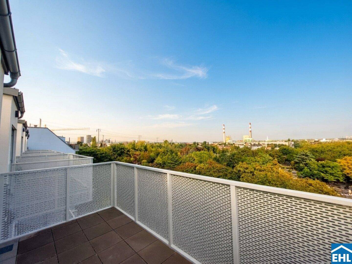 Balkon mit Blick ins Grüne und auf die Stadt, ausgestattet mit modernen Metallgeländern.