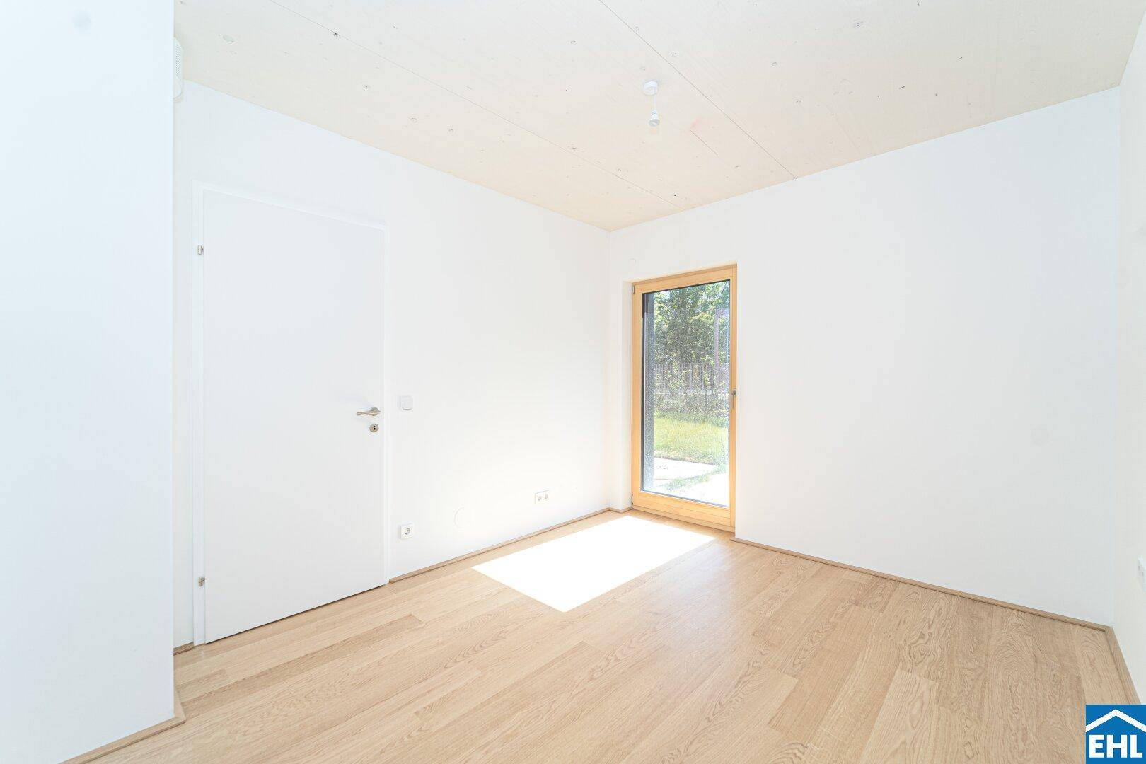 Freundliches Schlafzimmer mit Parkettboden und direktem Zugang zum Außenbereich.