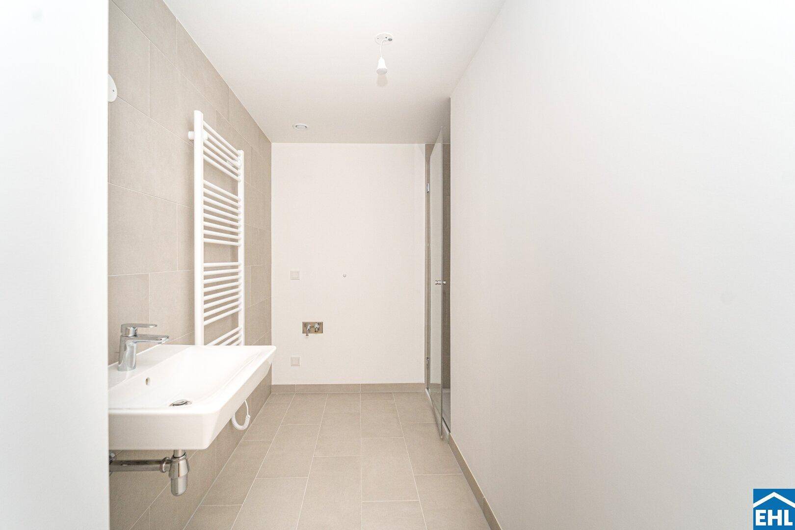 Modernes Badezimmer mit großem Waschbecken, Fliesenboden und beheiztem Handtuchhalter.